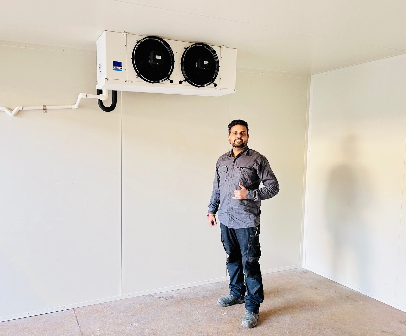 Heat Wave Solutions refrigeration technician beside a walk-in chiller installation
